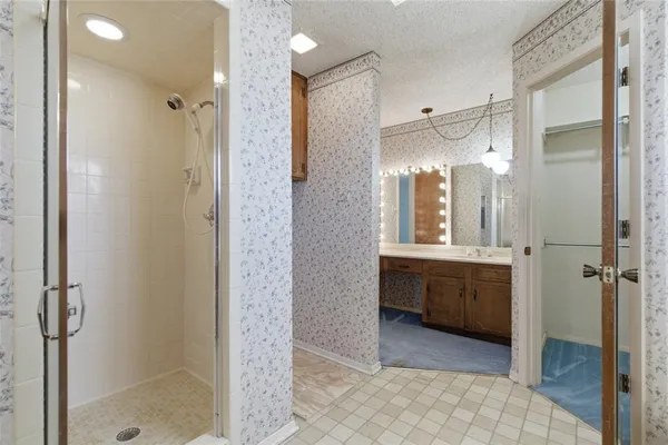 a bathroom with a granite countertop white cabinets and a sink