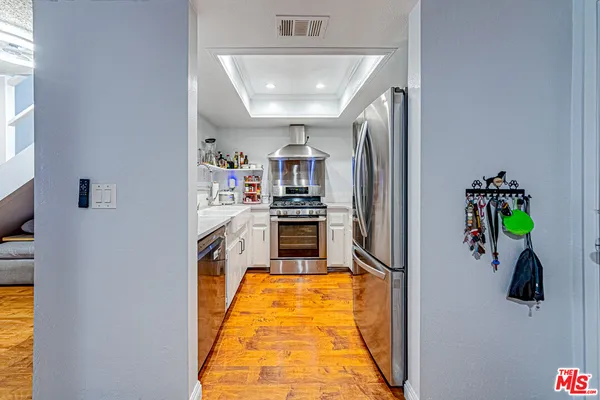a kitchen with stainless steel appliances granite countertop a refrigerator and a stove