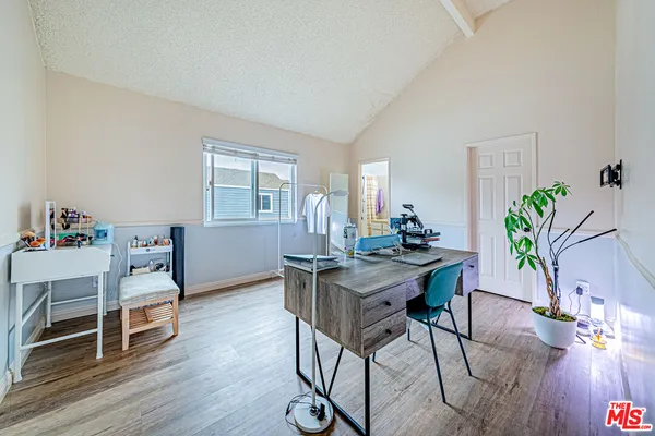 a view of a workspace with furniture and wooden floor