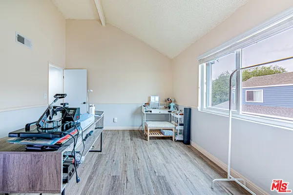 a view of a workspace with furniture and wooden floor