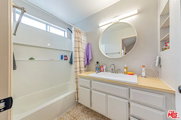 a bathroom with a tub sink and a mirror