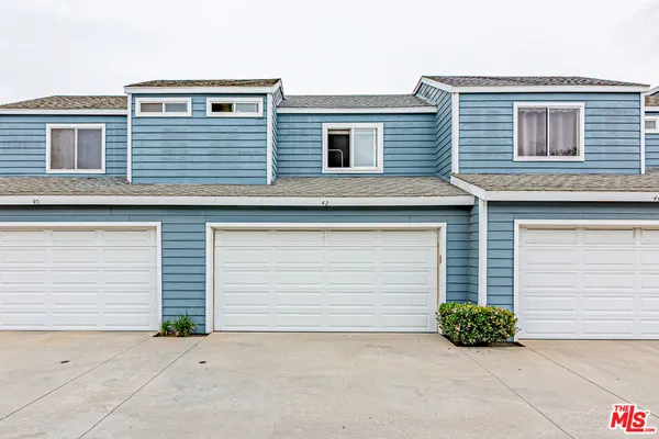 a small white building with a large window and garage