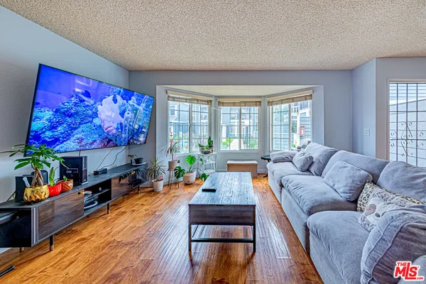 a living room with furniture a flat screen tv and a large window