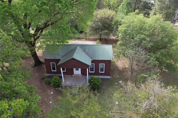an aerial view of a house with garden space and sitting area