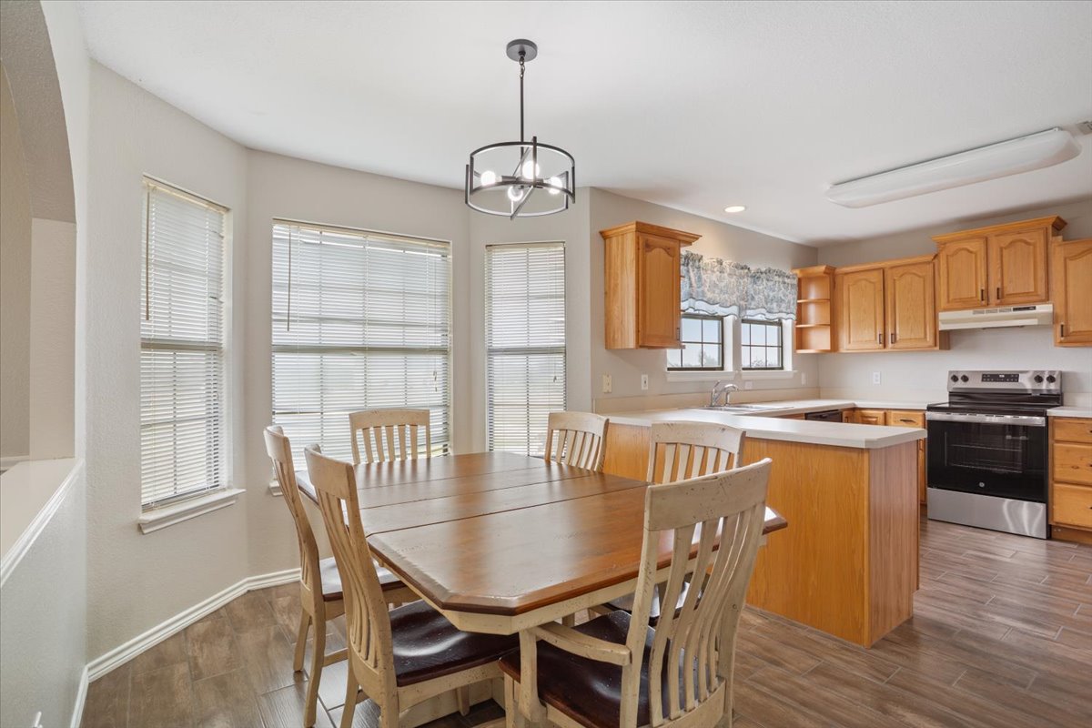 8600 Five Wells Road Rogers, TX 76569 - Photo 33 of 40 Dining space with dark wood finished floors, a chandelier, and recessed lighting