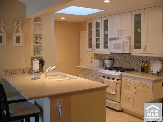a kitchen with granite countertop a sink cabinets and stove