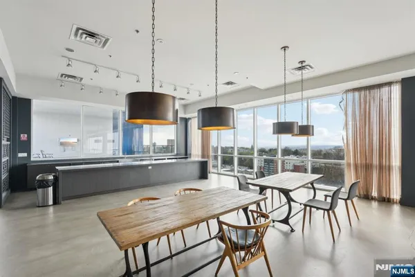 a kitchen with granite countertop a stove a sink a dining table and chairs with wooden floor