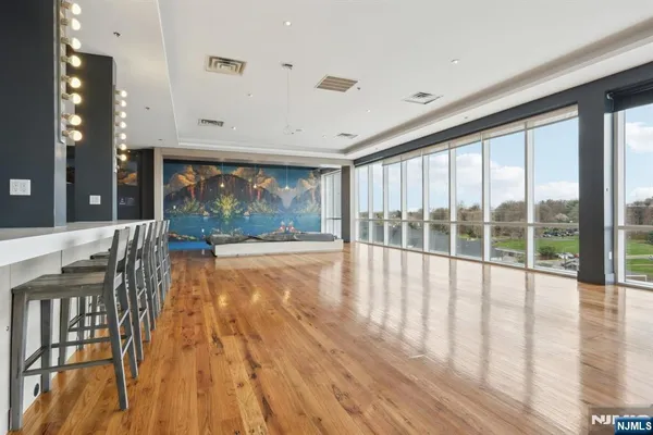 a view of an empty room with wooden floor and a large window