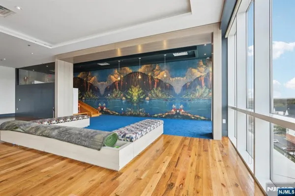 a living room with a bed and a painting on the wall