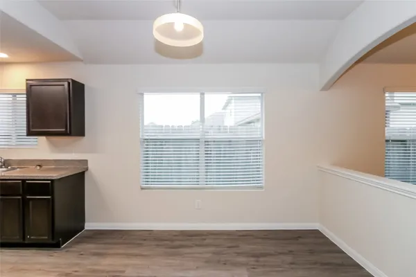 a view of empty room with wooden floor