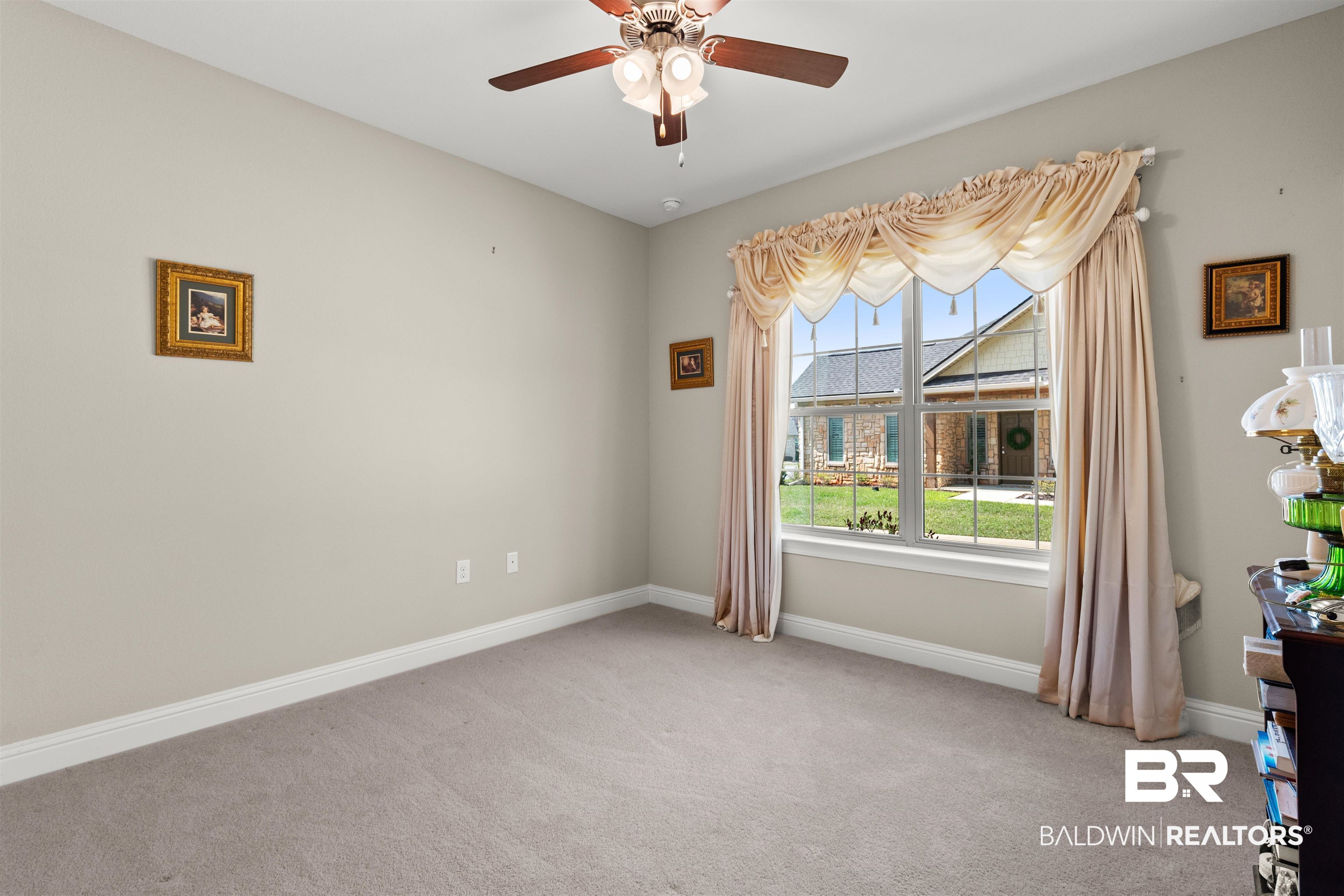 301 Holmes Avenue, Unit 301 Foley, AL 36535 - Photo 30 of 54 Empty room with a ceiling fan, baseboards, and light carpet