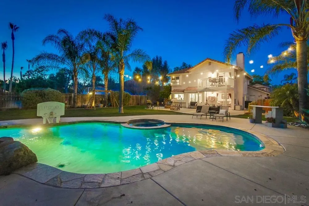 a view of a swimming pool with a table and chairs under an umbrella
