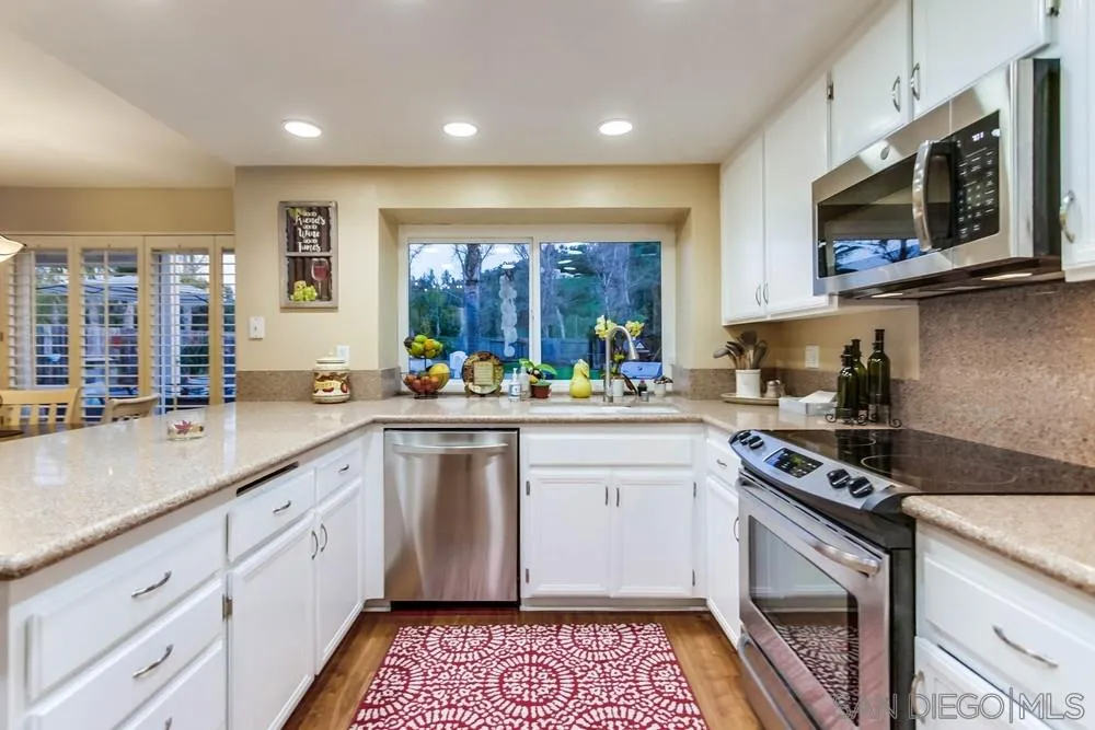 13919 Poway Valley Road Poway, CA 92064 - Photo 27 of 70 a kitchen with stainless steel appliances granite countertop a stove a sink and a microwave