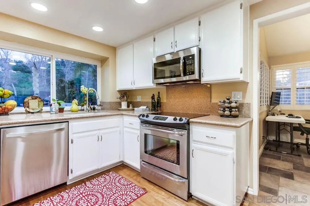 13919 Poway Valley Road Poway, CA 92064 - Photo 30 of 70 a kitchen with stainless steel appliances white cabinets a sink and a stove
