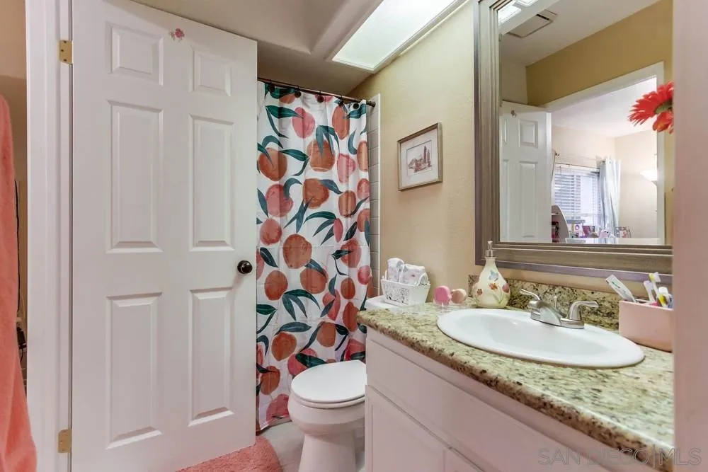 13919 Poway Valley Road Poway, CA 92064 - Photo 44 of 70 a bathroom with a granite countertop sink and a mirror with toilet