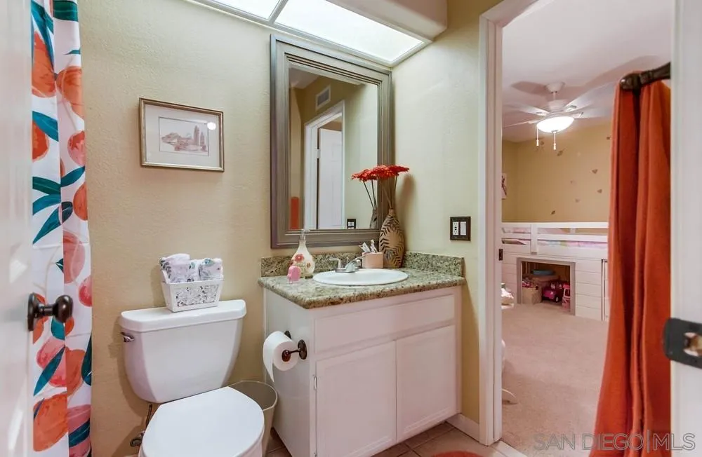 13919 Poway Valley Road Poway, CA 92064 - Photo 45 of 70 a bathroom with a granite countertop toilet a sink and a mirror