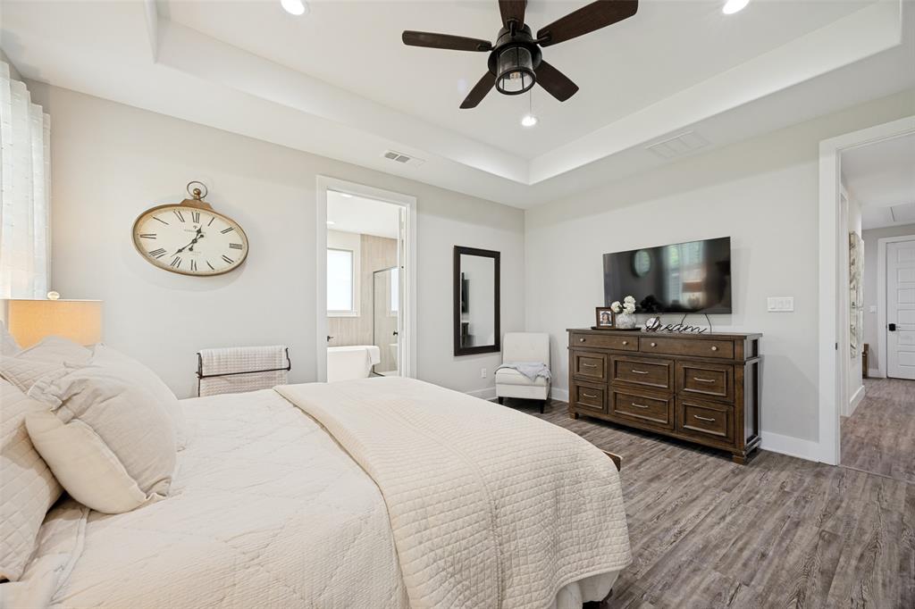 1105 Ranch Drive Bonham, TX 75418 - Photo 10 of 25 Spacious room featuring wood-finish flooring, a tray ceiling, and a ceiling fan with integrated lighting
