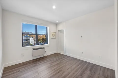 an empty room with wooden floor and window