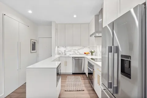 a kitchen with white cabinets and stainless steel appliances