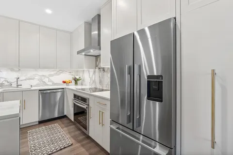 a kitchen with stainless steel appliances a refrigerator sink and cabinets