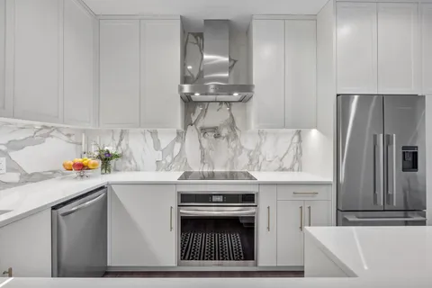 a kitchen with stainless steel appliances kitchen island a sink stove and refrigerator