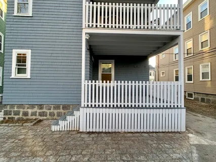 a view of a brick house with wooden deck