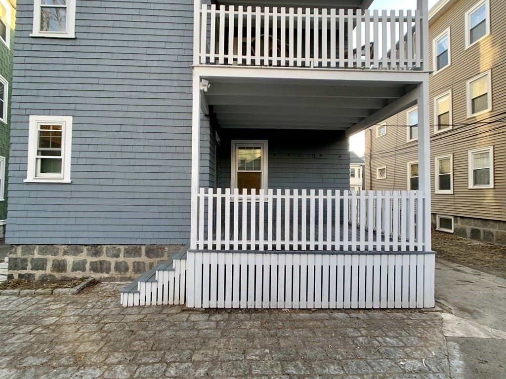 12 Rosemary Street, Unit 1 Boston, MA 02130 - Photo 16 of 17 a view of a brick house with wooden deck