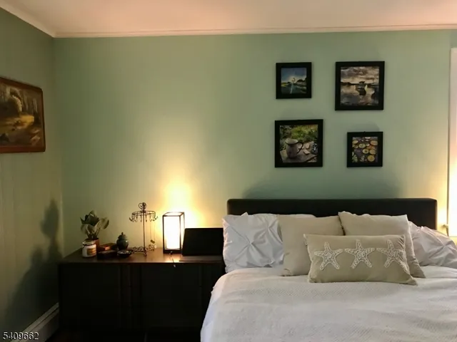 a bed room with a bed and a lamp on dresser