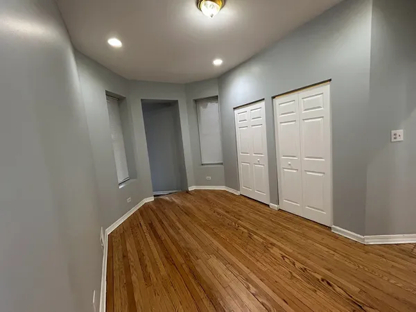a view of empty room with wooden floor
