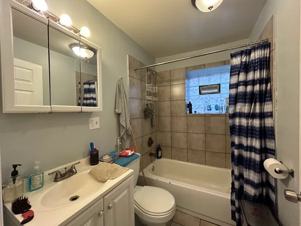 a bathroom with a sink toilet vanity and shower