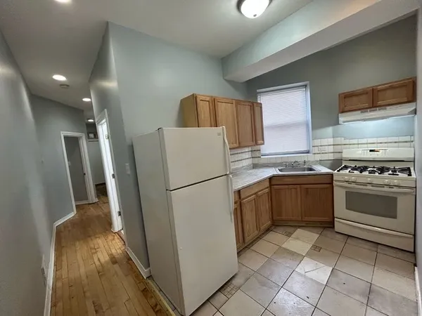 a white refrigerator freezer and a stove sitting inside of a kitchen