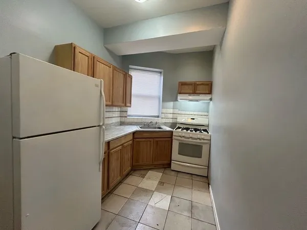 a white refrigerator freezer and a stove in a kitchen