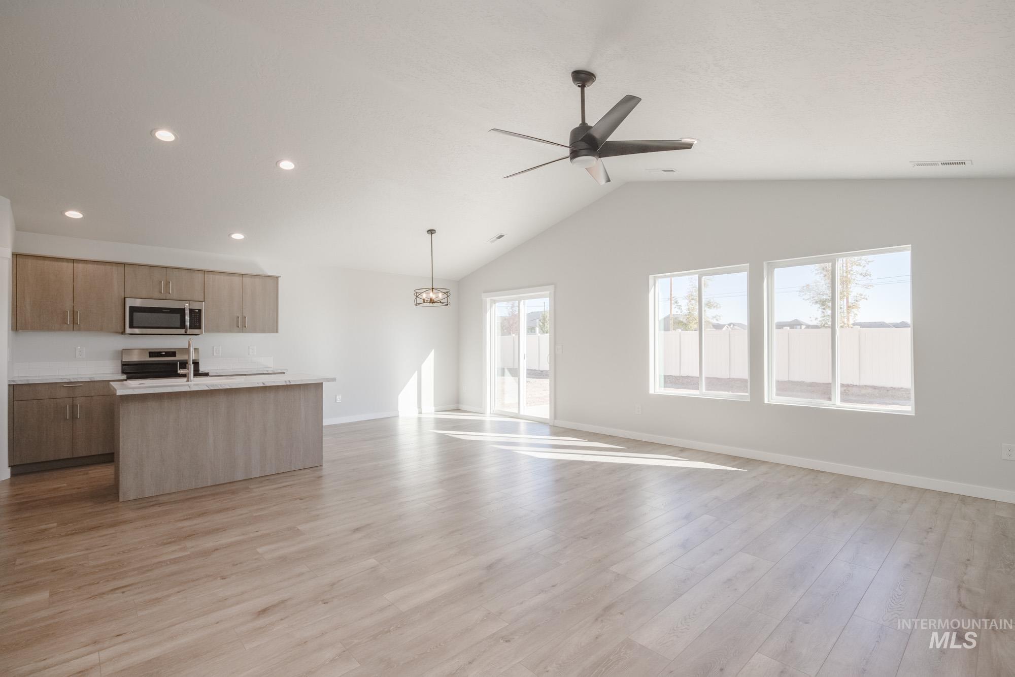 13735 Inman Court Caldwell, ID 83607 - Photo 22 of 22 Kitchen featuring open floor plan, a kitchen island with sink, light countertops, stainless steel appliances, and light wood-type flooring