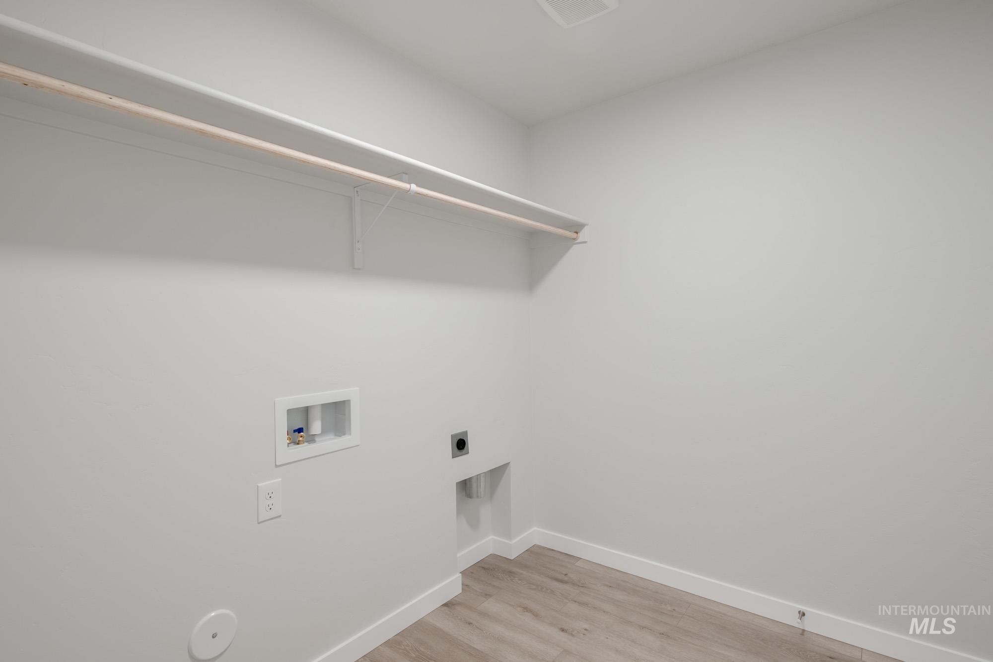 13735 Inman Court Caldwell, ID 83607 - Photo 16 of 22 Laundry area featuring light wood finished floors, electric dryer hookup, and hookup for a washing machine