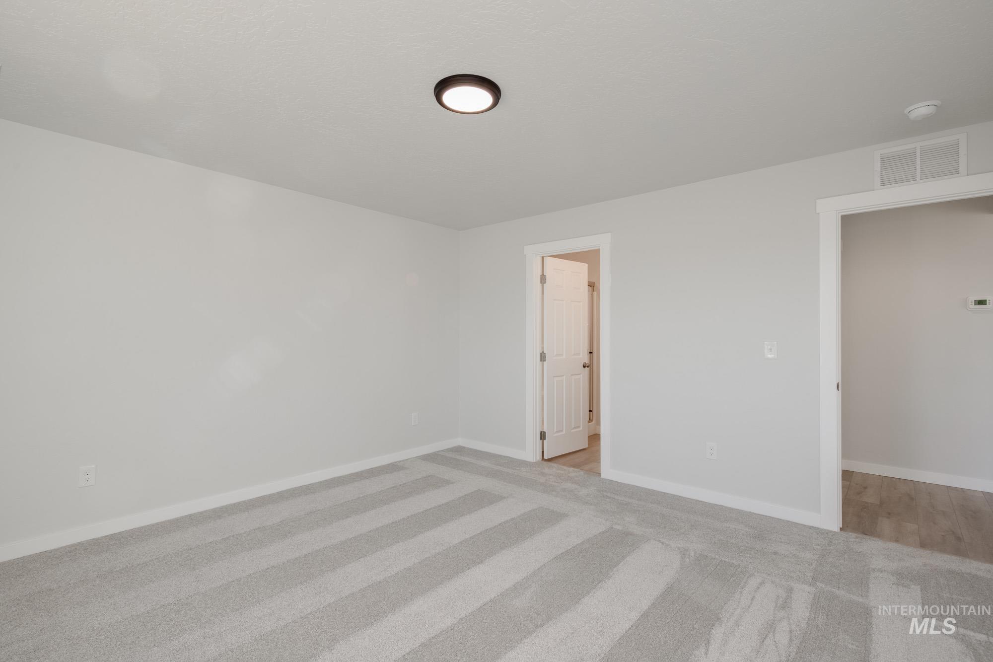 13735 Inman Court Caldwell, ID 83607 - Photo 18 of 22 Unfurnished bedroom featuring light carpet and baseboards