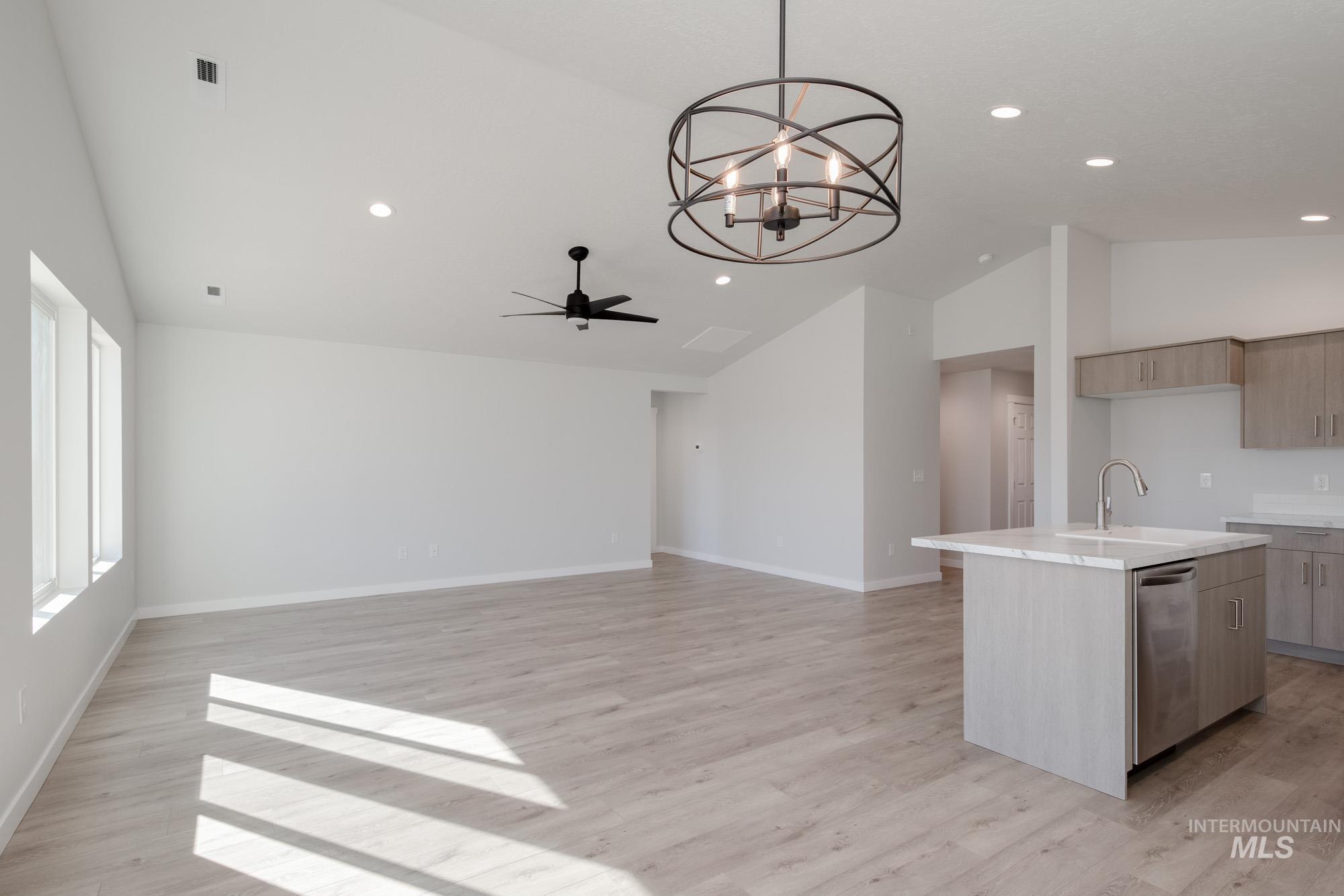 13735 Inman Court Caldwell, ID 83607 - Photo 9 of 22 Kitchen with vaulted ceiling, a kitchen island with sink, suspended lighting, a ceiling fan, and stainless steel dishwasher