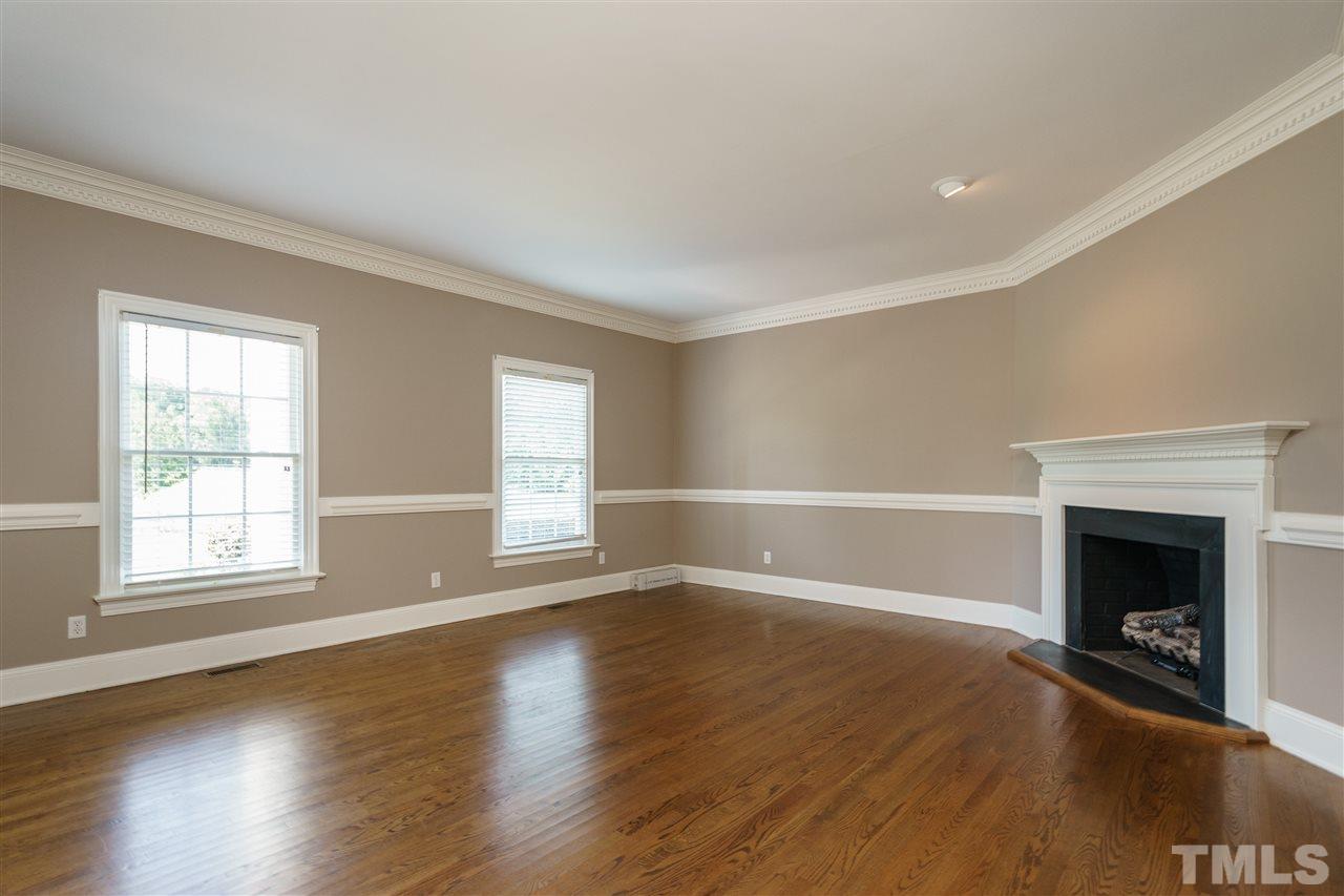 8446 Seven Paths Road Spring Hope, NC 27882 - Photo 4 of 24 an empty room with wooden floor fireplace and windows