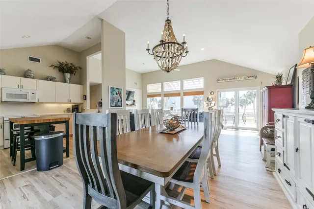 a kitchen with granite countertop a table chairs stove and cabinets