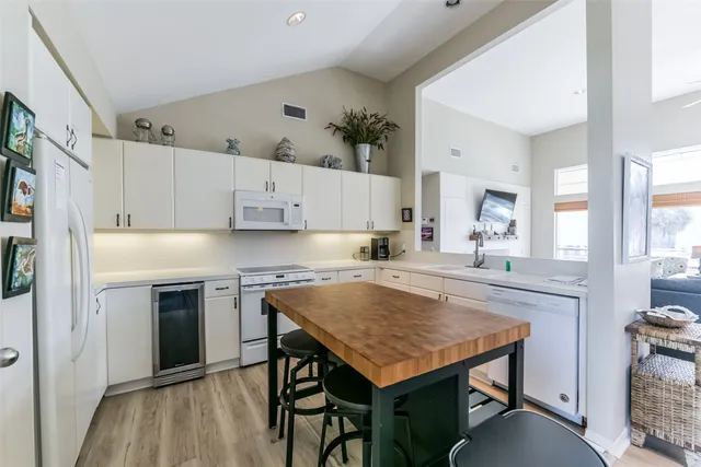 a kitchen with granite countertop white cabinets and white appliances