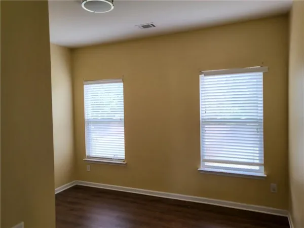 a view of a room with wooden floor and windows