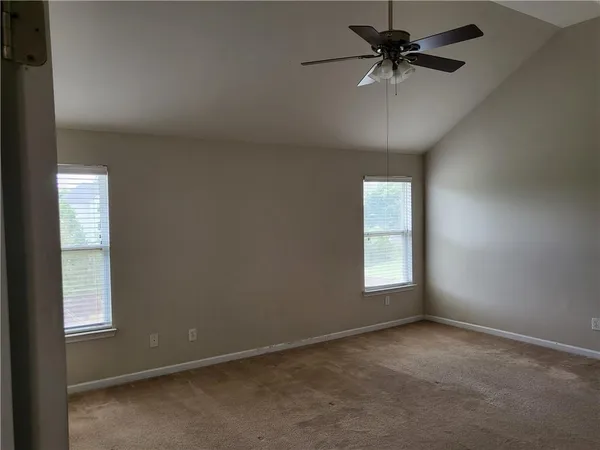 en empty room with windows and fan