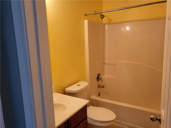 a bathroom with a granite countertop toilet and a shower