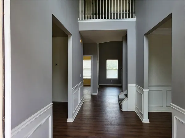 a view of a hallway with wooden floor and staircase