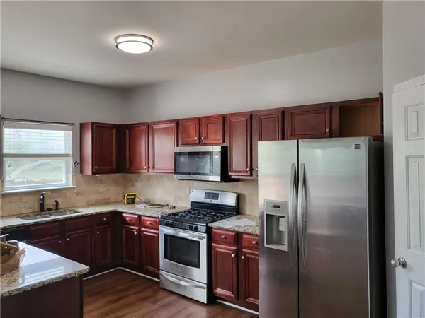 a kitchen with a refrigerator sink and wooden cabinets