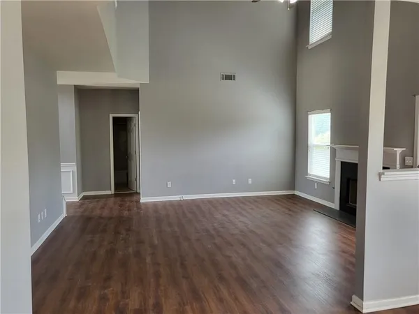a view of a livingroom with wooden floor and a kitchen