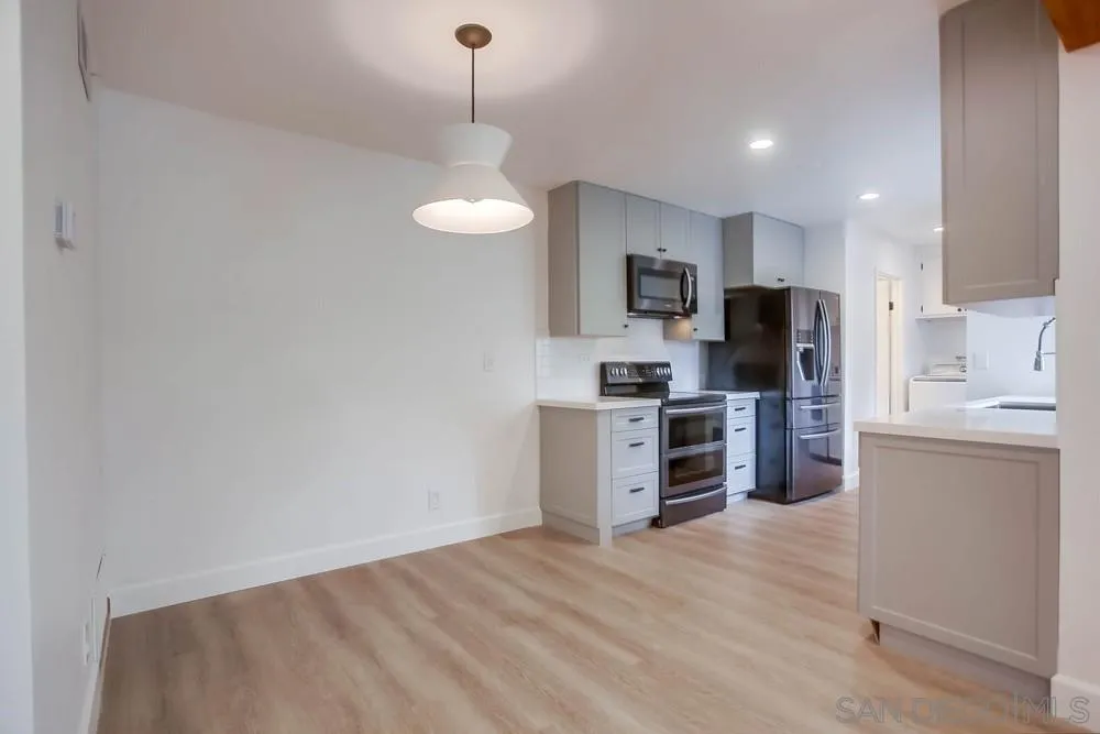 1228 Evergreen Drive Cardiff, CA 92007 - Photo 8 of 37 a kitchen with kitchen island microwave stove refrigerator and cabinets