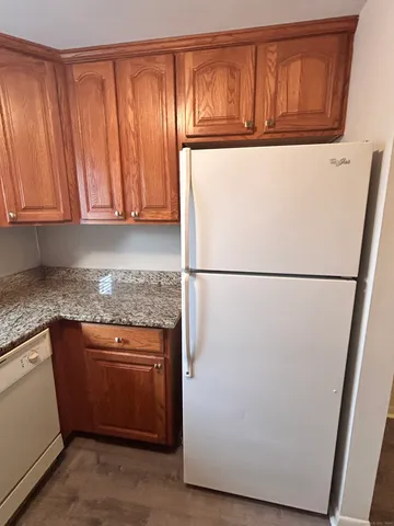 a kitchen with stainless steel appliances granite countertop a refrigerator a sink and a cabinets