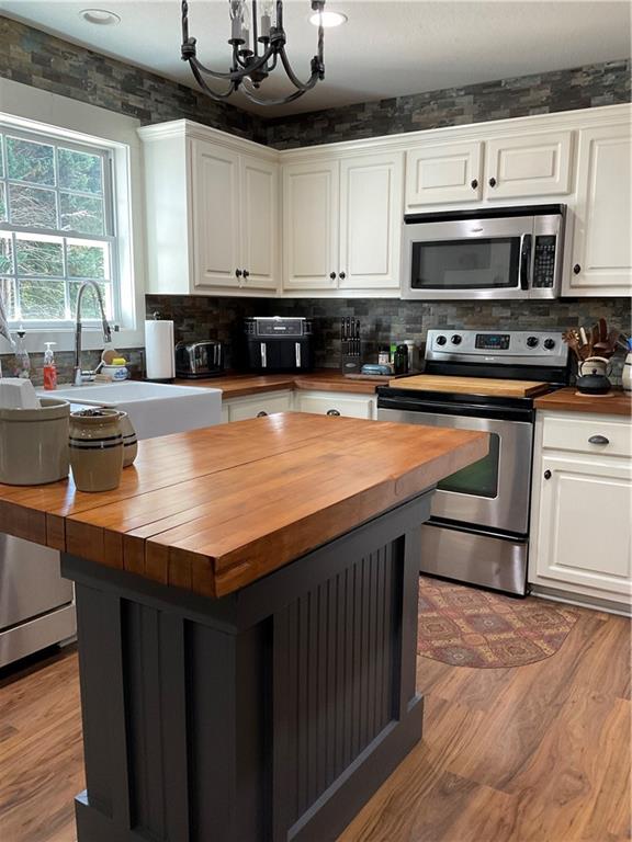 5403 Stone Trace Gainesville, GA 30504 - Photo 36 of 126 a kitchen with stainless steel appliances a stove sink microwave and cabinets