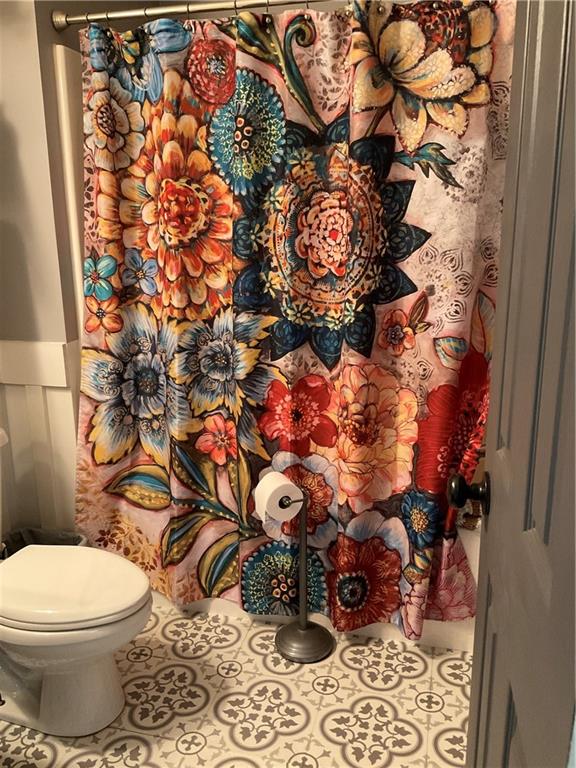 5403 Stone Trace Gainesville, GA 30504 - Photo 81 of 126 a bathroom with a toilet and a shower curtain
