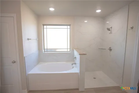 a white bath tub sitting next to a shower
